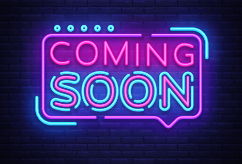 A pink and blue neon sign with the words 'Coming Soon' on a black background